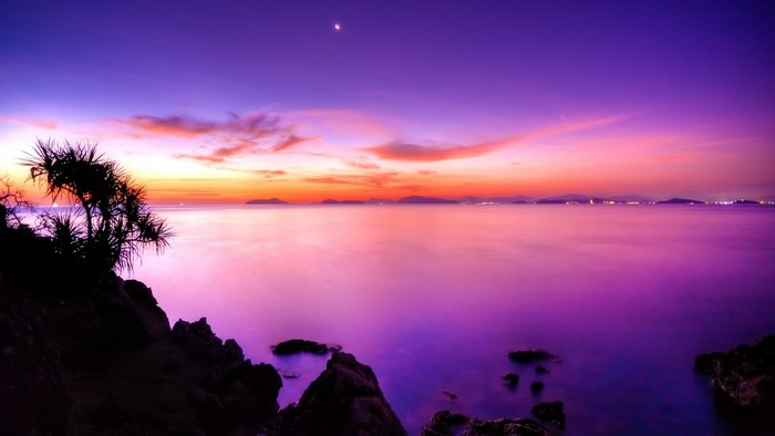 Moonrise over ocean at sunset