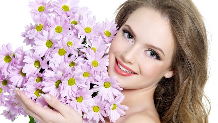 Woman holding a bouquet of pink daisies