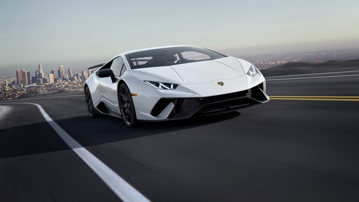 White Lamborghini Driving on a Road with Cityscape