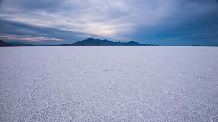 Salt Flats with Mountains Under Cloudy Sky