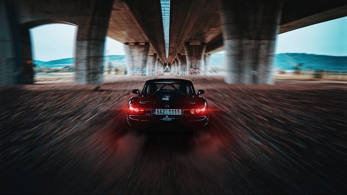 Mazda MX-5 driving under a bridge