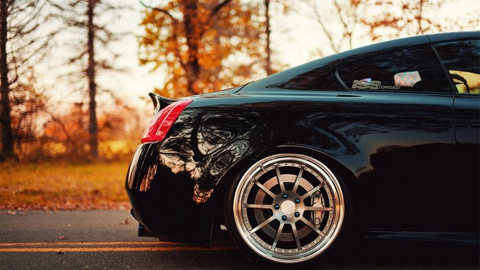 Black Infiniti G37 coupe with custom wheels in autumn