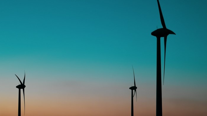 Wind turbines silhouetted against a gradient sky