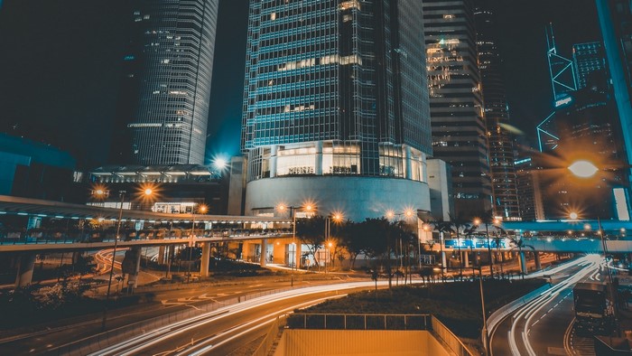Night city skyline with skyscrapers and light trails