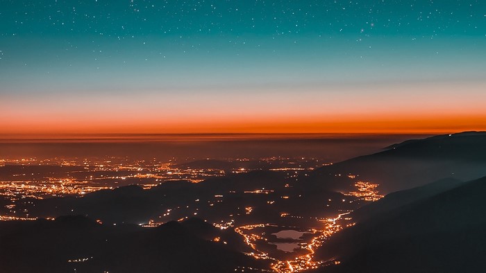 City lights at dusk with starry sky