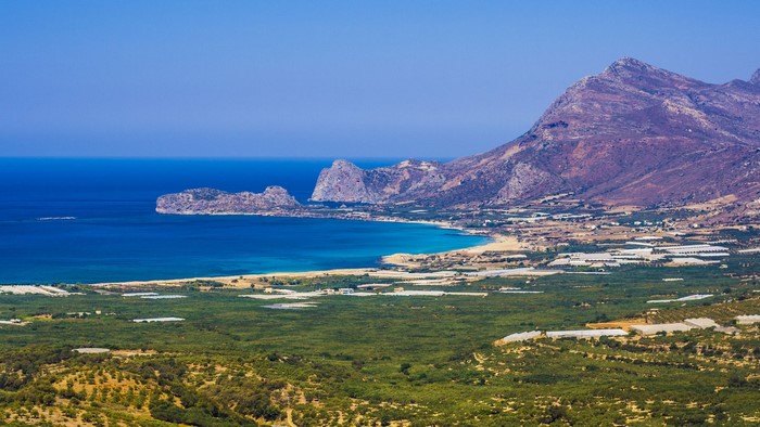 Coastal landscape with mountains and greenhouses in Greece