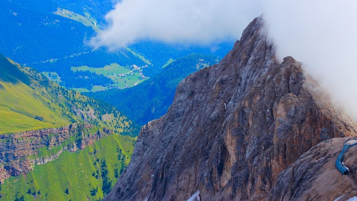Mountain peak with clouds and green valley