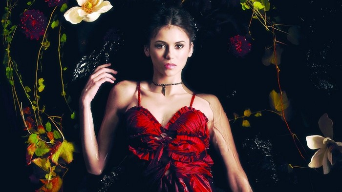 Brunette woman in red dress surrounded by flowers