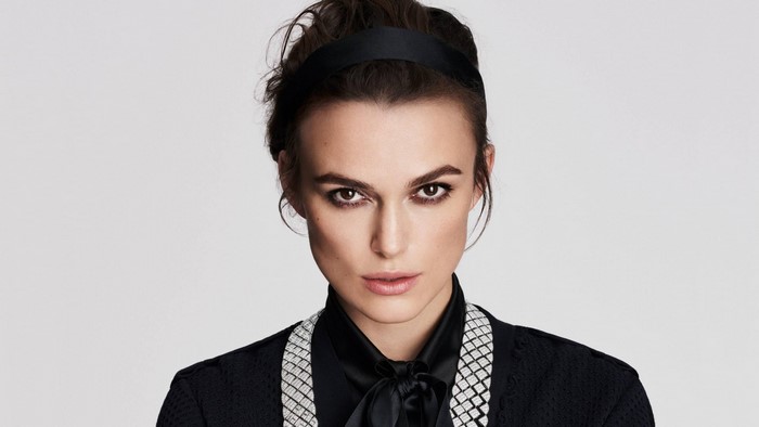 Keira Knightley wearing a black headband and jacket