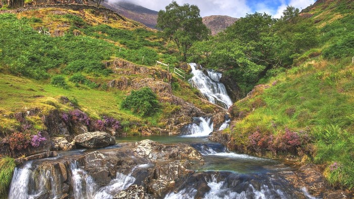 Winding waterfall in a green mountain landscape