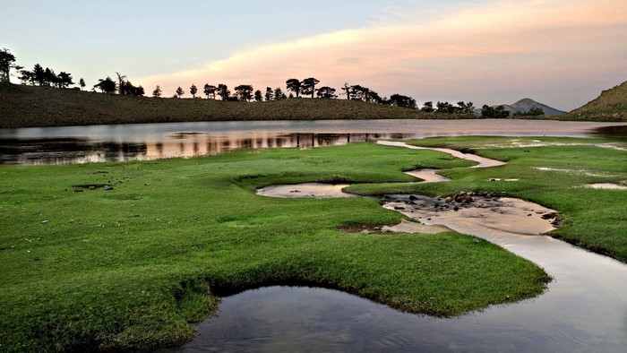 Wet meadows with a winding stream and lake