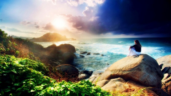 Girl sitting on a rock by the sea