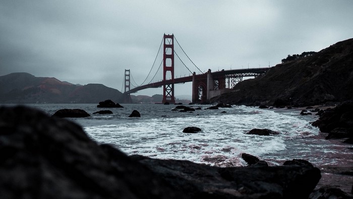 Golden Gate Bridge over water with rocky shore