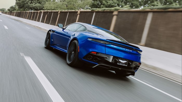 Blue Aston Martin DBS Superleggera driving on highway
