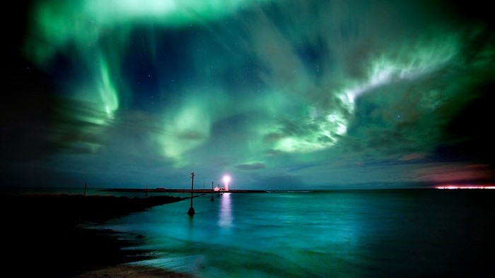 Northern lights over the sea with lighthouse