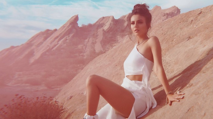Victoria Justice in a white dress in a desert landscape