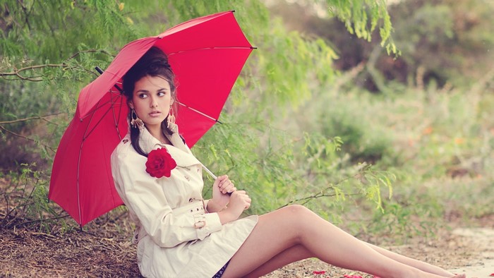 Woman with red umbrella and rose