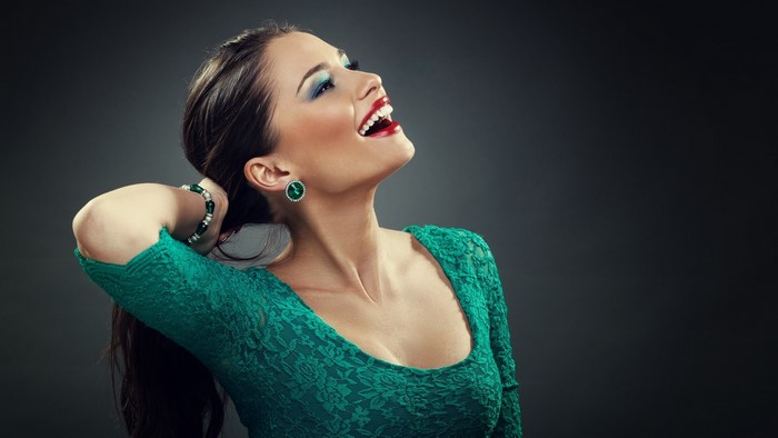 Model in green dress with makeup and jewelry