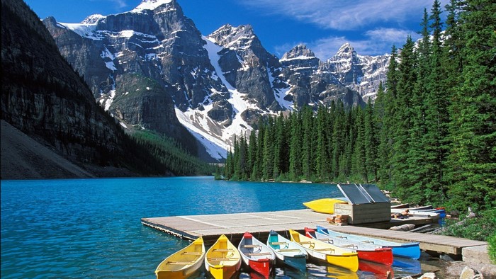Canoes on a dock by a mountain lake