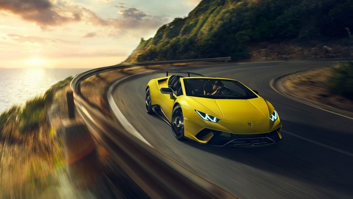 Yellow Lamborghini Huracan driving on coastal road