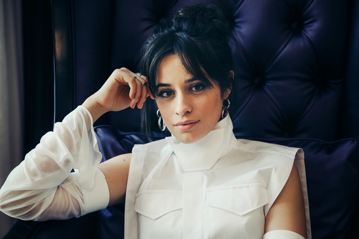 Camila Cabello sitting in a chair