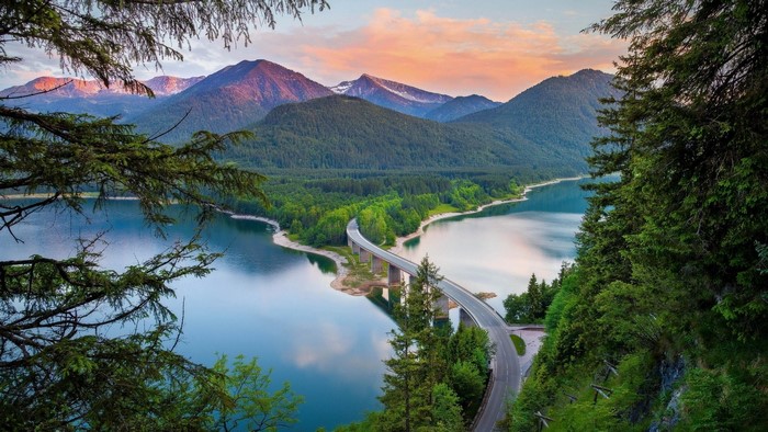 Lake and bridge with mountains at sunset