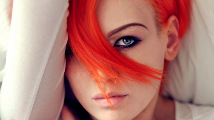 Woman with bright orange hair and blue eyes