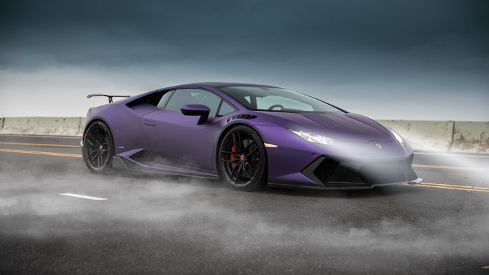 Purple Lamborghini Huracan on a foggy road