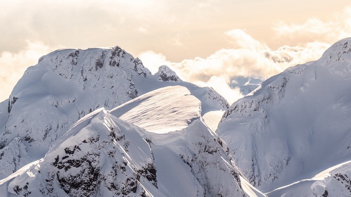 Snow-covered mountain range under a cloudy sky