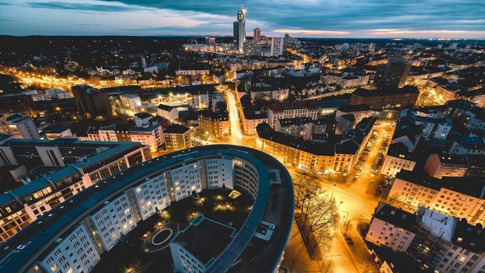 Aerial view of a city at dusk with illuminated buildings