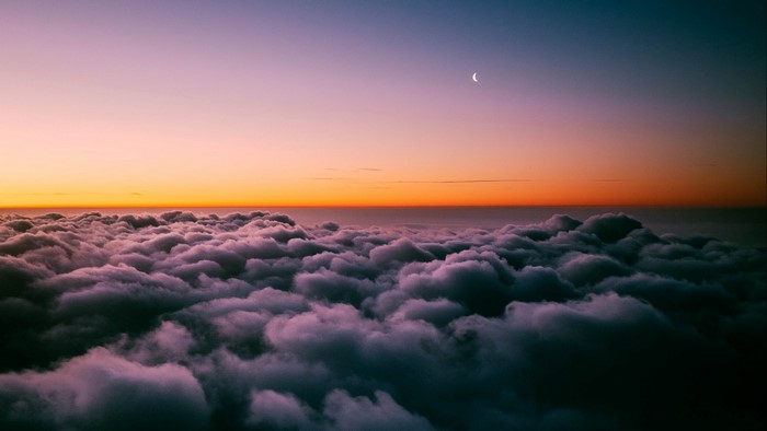 Clouds at sunset with crescent moon