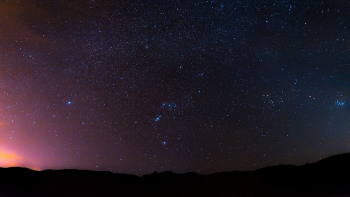 Night sky full of stars over a silhouette of hills