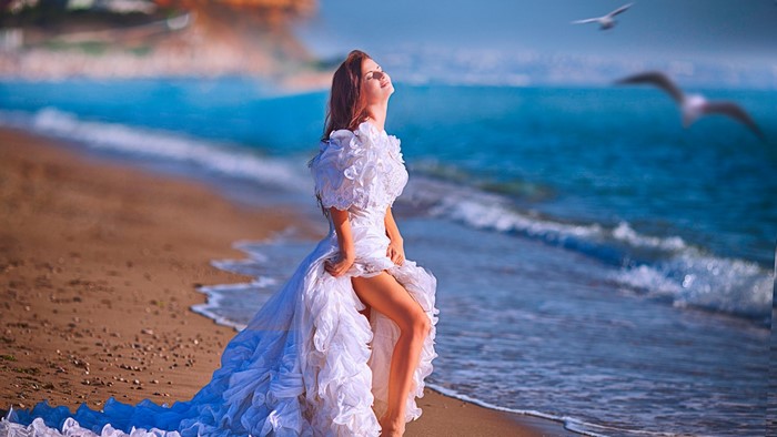Bride in a white dress on the beach