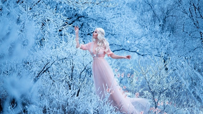 Woman in pink dress in a frosted forest