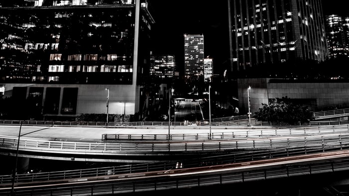 Night highway with city buildings