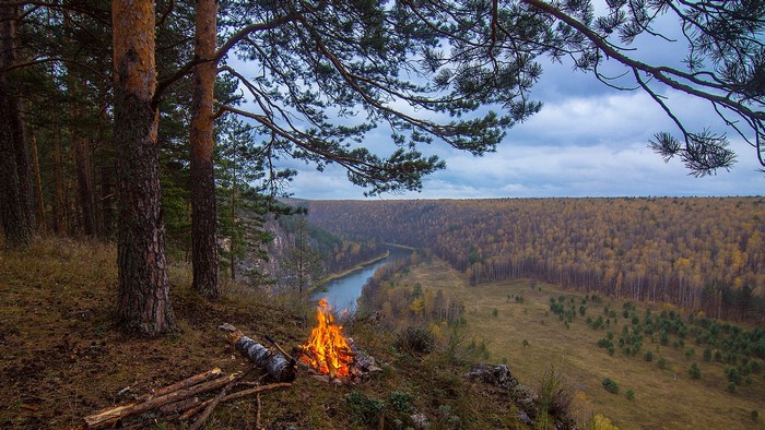 Campfire overlooking a river valley in autumn
