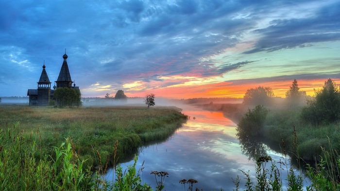 Wooden church by river at sunrise, Arkhangelsk region