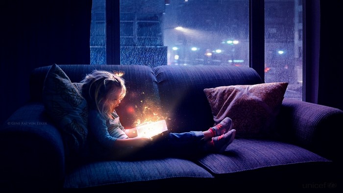 Girl reading a magic book with glowing light