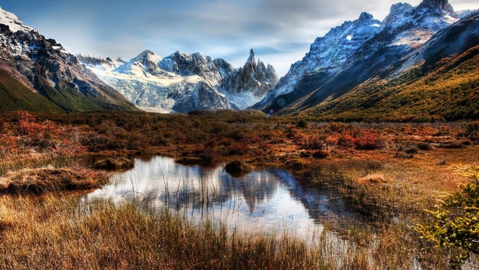 Mountain lake with autumn foliage and snow-capped peaks