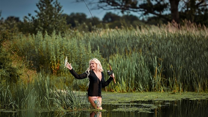 Woman fishing and holding a caught fish