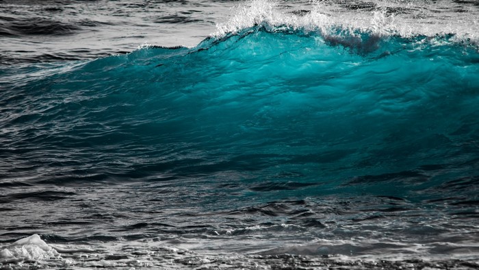 Turquoise wave crashing with white foam