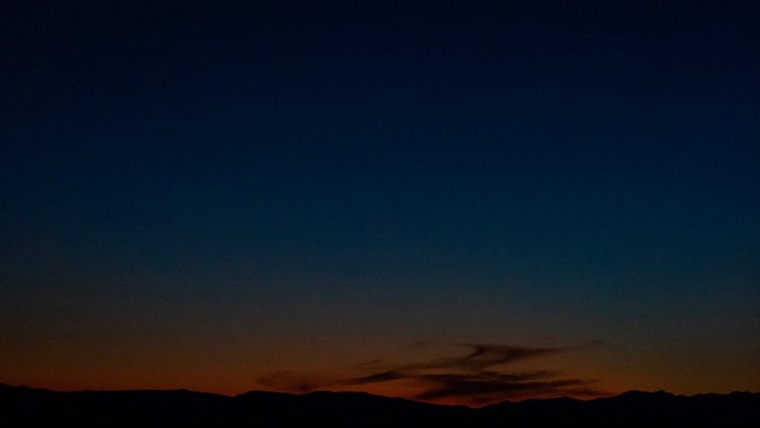 Dark blue night sky over silhouetted mountains