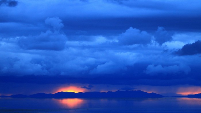 Blue clouds over a body of water at dawn