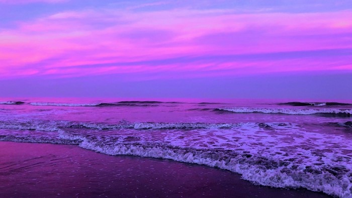 Purple ocean waves at sunset