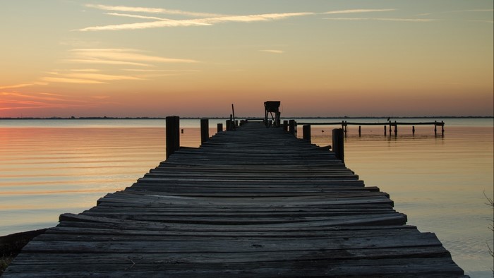 Wooden pier on a calm lake at sunset