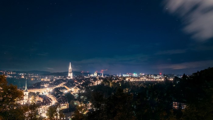 Night view of a city with a prominent church spire