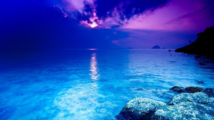 Sunset over the sea with purple clouds