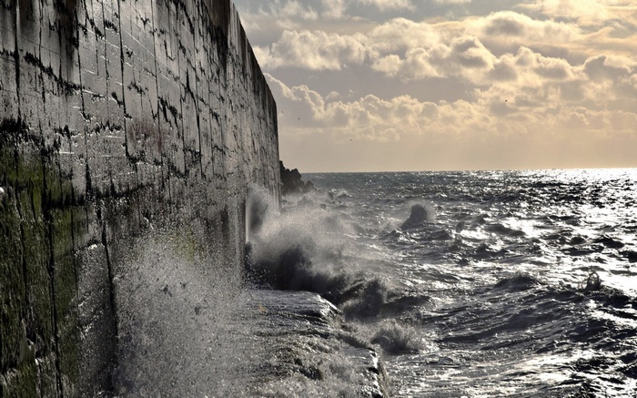 Waves crashing against a stone wall