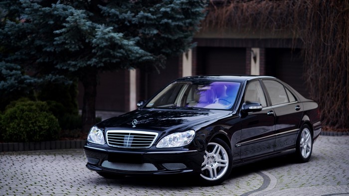 Black Mercedes-Benz S-Class W220 parked on a cobblestone driveway