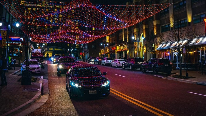 Night street decorated with Christmas lights and cars